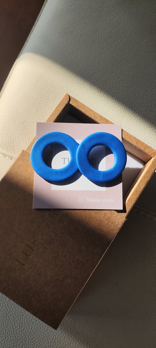 DORA: Pendientes en forma de círculo en color azul metalizado.